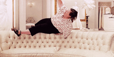 Woman Laying On White Couch With Arms Up GIF