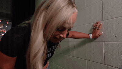 Woman Leaning Against Brick Wall GIF