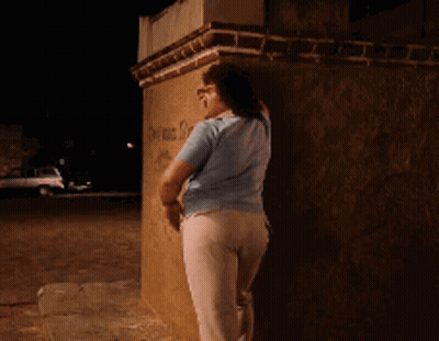 Woman Leaning Against Brick Wall With Graffiti I'm Sorry GIF