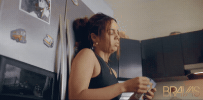 Woman Leaning Against Refrigerator With Bravas GIF