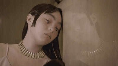 Woman Leaning Against Wall With Reflection GIF