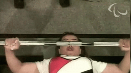Woman Lifts Barbell Row While Laying Down GIF