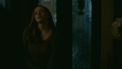 Woman Looking At Camera In Dark Room GIF