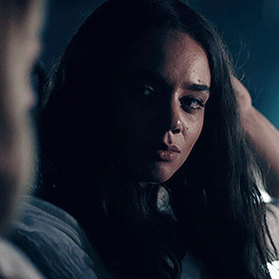 Woman Looking At Camera In Dark Room GIF