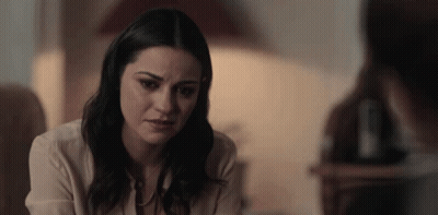 Woman Looking At Camera With Man In Background GIF