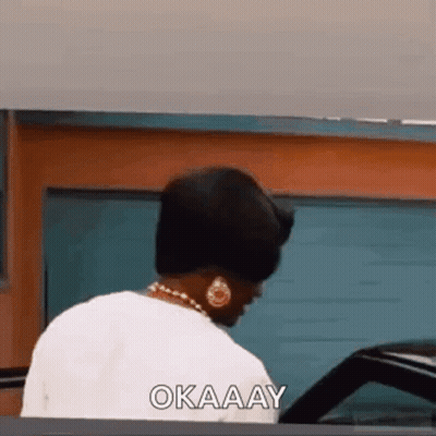 Woman Looking At Car Saying Okay By Garage Door GIF