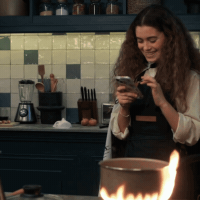 Woman Looking At Cell Phone In Kitchen GIF