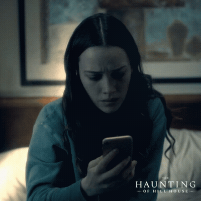 Woman Looking At Cell Phone With The Haunting Of Hill House GIF