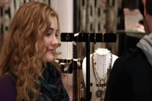 Woman Looking At Display Of Necklaces And Bracelets GIF