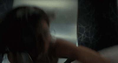 Woman Looking At Herself In Mirror In Dark Room GIF