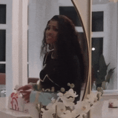 Woman Looking At Herself In Mirror With Flowers GIF