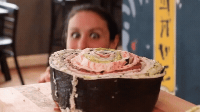 Woman Looking At Large Sushi Roll GIF