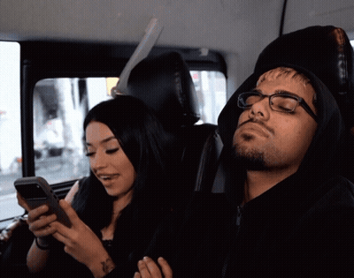 Woman Looking At Phone While Man Sleeps GIF