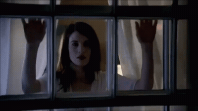 Woman Looking Out Window With Hands On Glass GIF