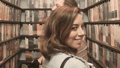 Woman Looking Over Shoulder In Library GIF