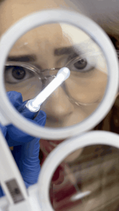 Woman Looking Through Magnifying Glass At Light GIF