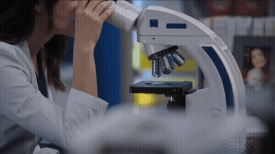 Woman Looking Through Microscope With CTV
