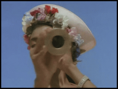 Woman Looking Through Telescope With Flower Hat GIF