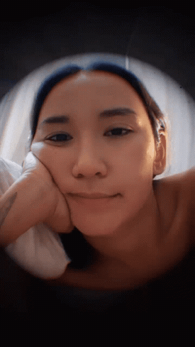 Woman Lying Down With Hand On Face GIF