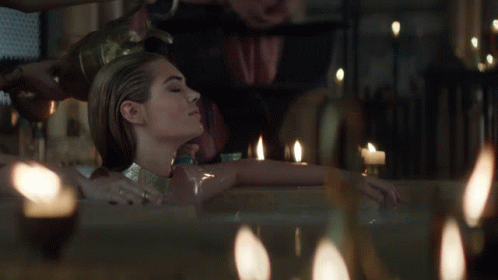 Woman Lying In Bathtub With Candles GIF
