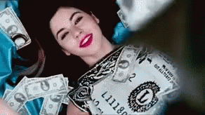 Woman Lying In Money With Dollar Bill GIF