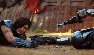 Woman Lying On Ground With Gun GIF