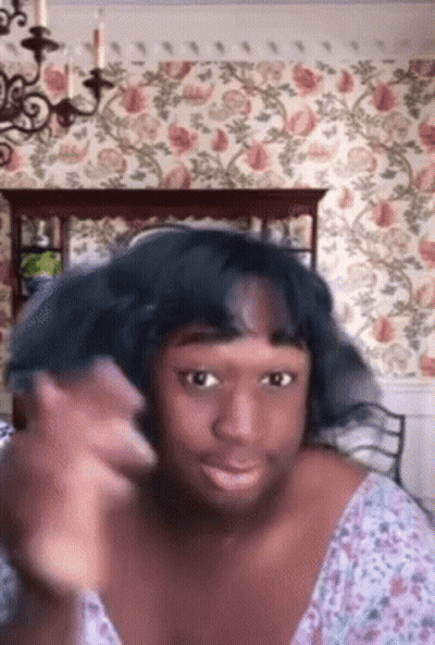 Woman Making Funny Face At Floral Wall GIF