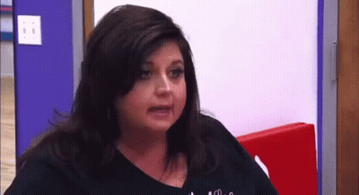 Woman Making Funny Face At Red Wall GIF