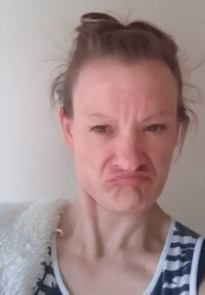 Woman Making Funny Face In Bun And Striped Shirt GIF