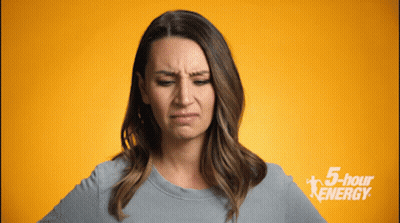 Woman Making Funny Face In Front Of 5 Hour Energy Sign GIF