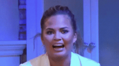 Woman Making Funny Face In Front Of Blue Wall GIF