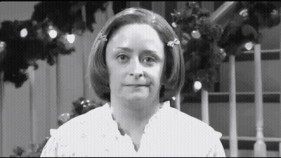 Woman Making Funny Face In Front Of Christmas Tree GIF
