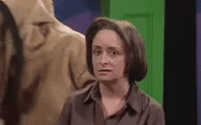Woman Making Funny Face In Front Of Green Door GIF