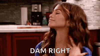 Woman Making Funny Face In Kitchen Holding Hand Saying Dam Right GIF