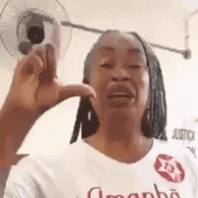 Woman Making Funny Face In White Shirt With Fan GIF
