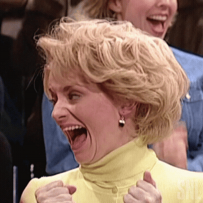 Woman Making Funny Face In Yellow Turtleneck And Earrings GIF