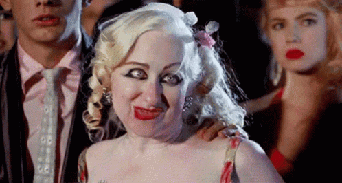Woman Making Funny Face Next To Man In Suit GIF