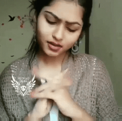 Woman Making Funny Face With Hands In Sweater And Earrings GIF
