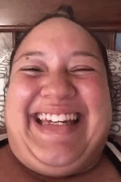 Woman Making Funny Face With Mouth Open On Bed GIF