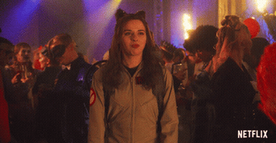 Woman Making Peace Sign In Front Of Crowd With Netflix Logo GIF