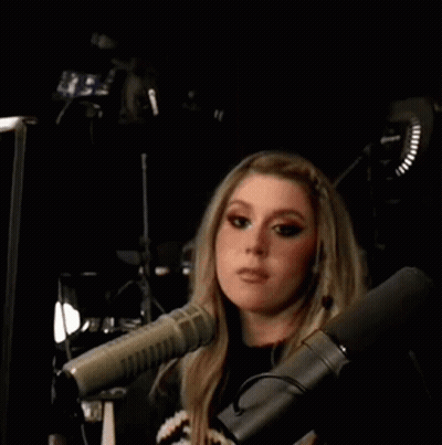 Woman Making Peace Sign in Front of Microphone