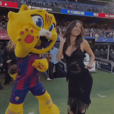 Woman Next To Cat Mascot In Front Of FC Barcelona Banner GIF