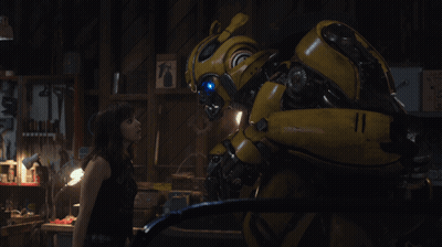 Woman Next To Yellow Robot In Dark Room GIF