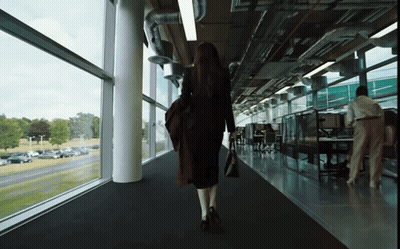 Woman On Balcony In Front Of House Surrounded By Trees GIF