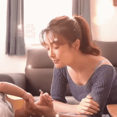 Woman On Couch Holding Baby's Hand GIF
