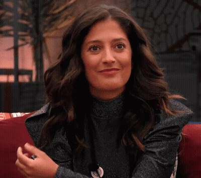 Woman On Couch Smiling Waving Hands GIF