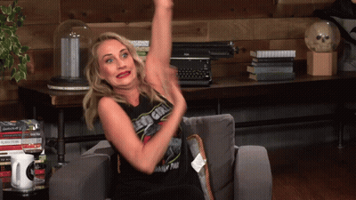 Woman On Couch With Arm Up Wearing Led Girl Shirt GIF