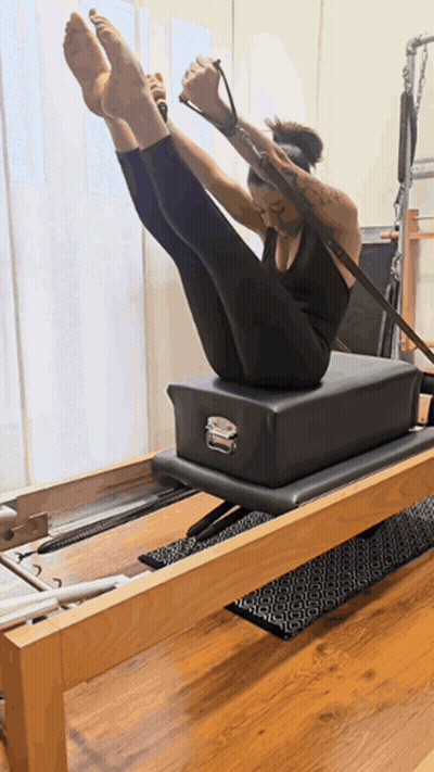 Woman On Pilates Machine Legs Up GIF