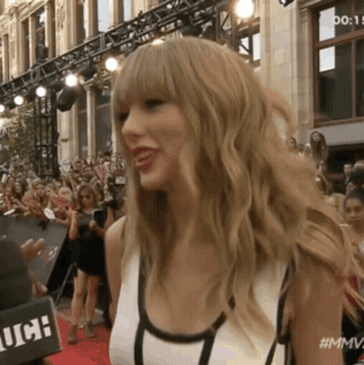 Woman On Red Carpet In Front Of Crowd Saying MMV GIF