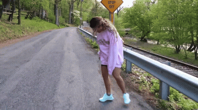 Woman On Road Near Drop Off Sign GIF